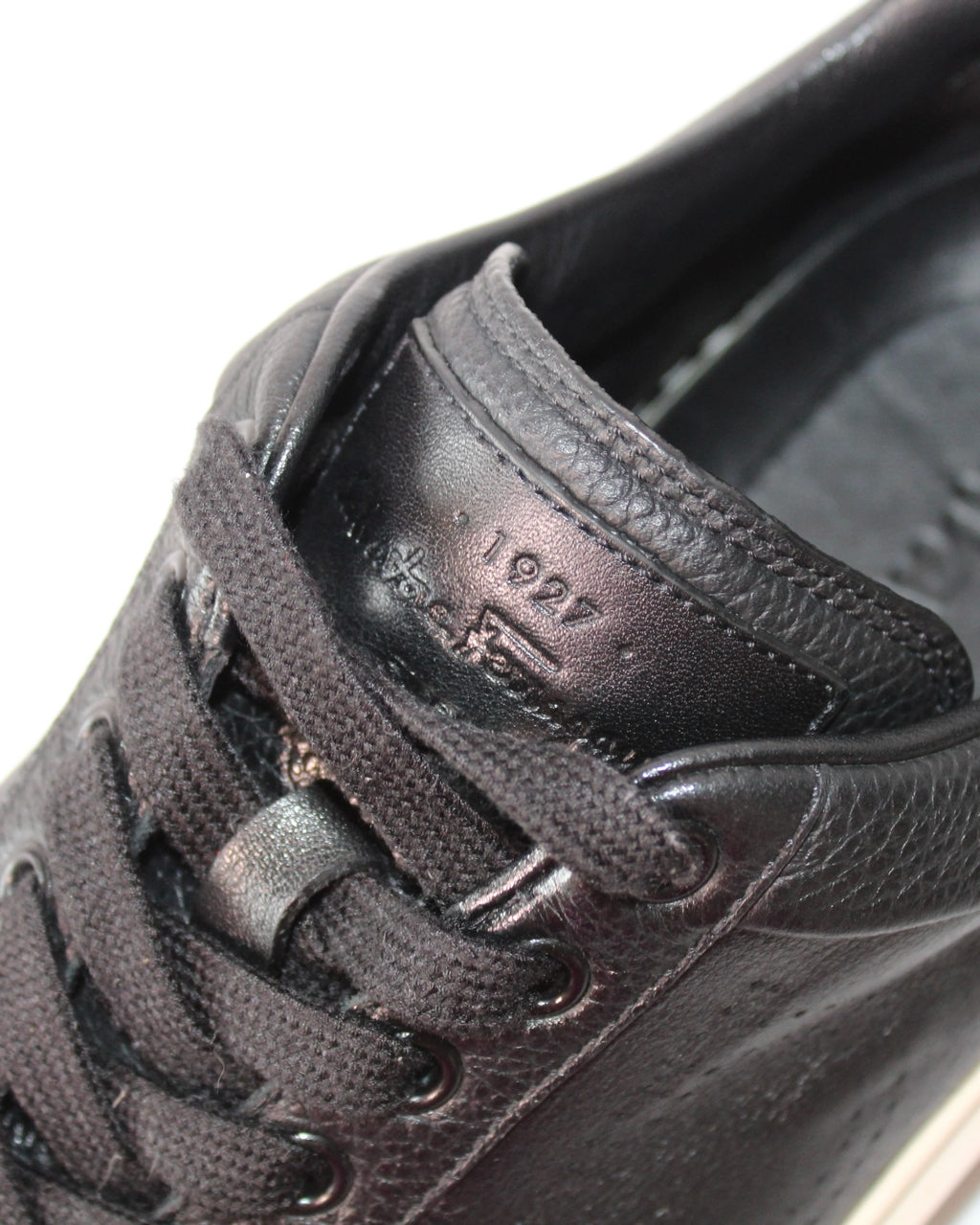 Detalle de tenis Hibiscx's Archive Salvatore Ferragamo en piel negra con grabado 1927 en la lengüeta